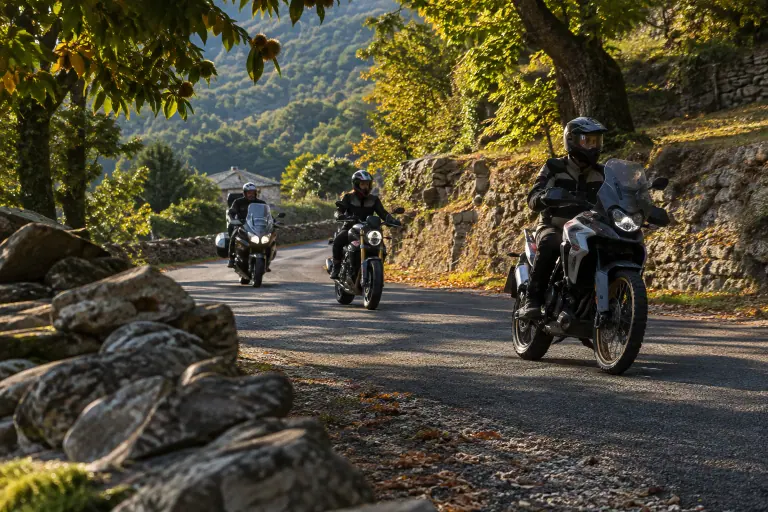 Sur une petite route des Cévennes bordée de châtaigniers, trois motards roulent en file indienne dans un virage, à bonne distance les uns des autres